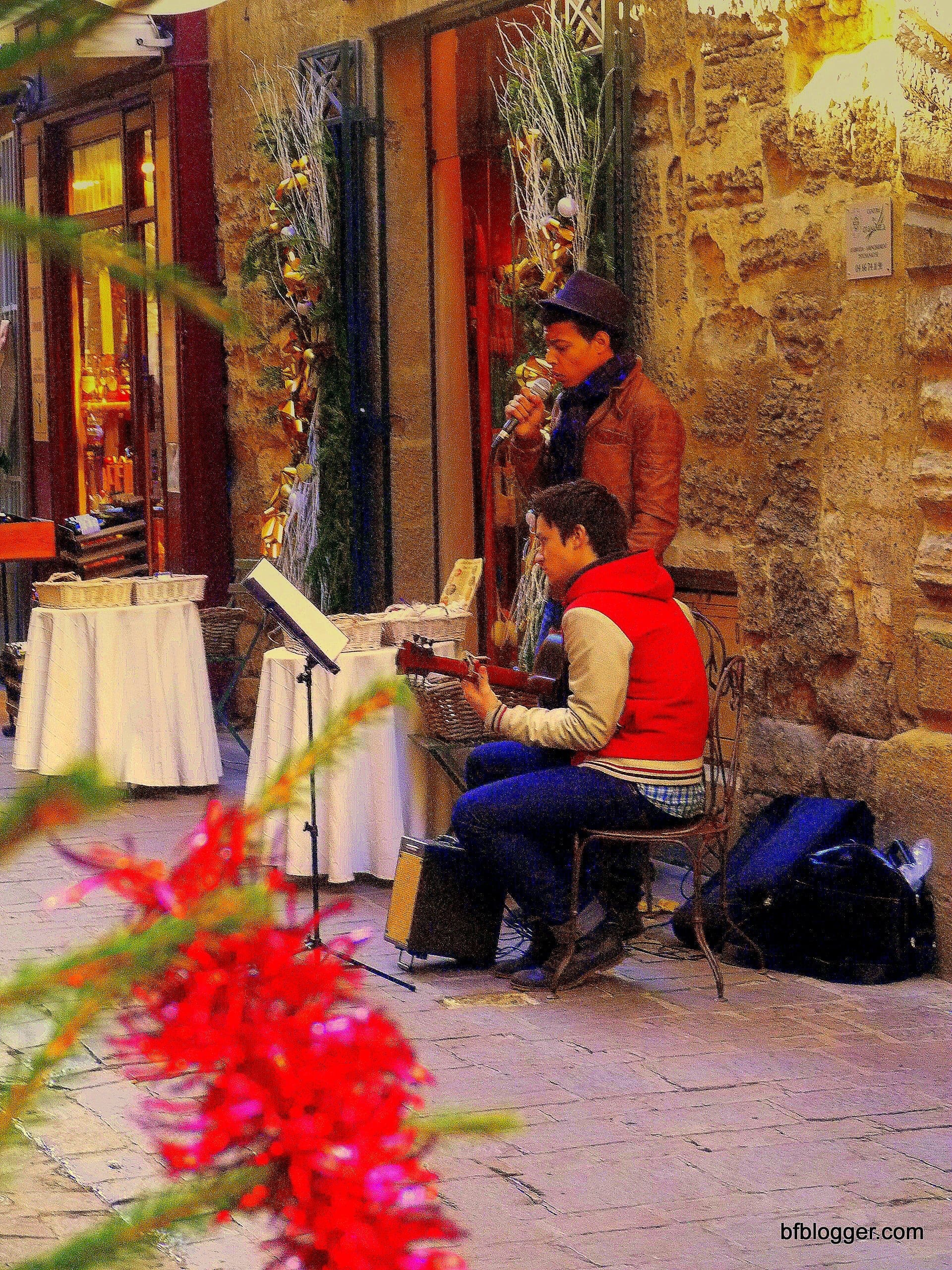 Musicians caroling on the sidewalks help create a oldtime holiday mood