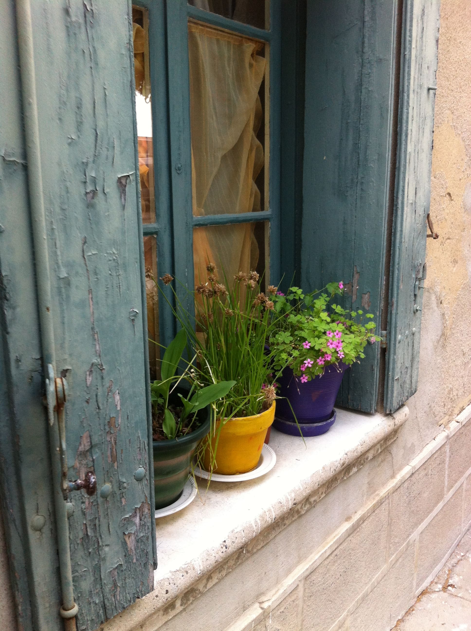 Un-shuttered windows and flowerpots 